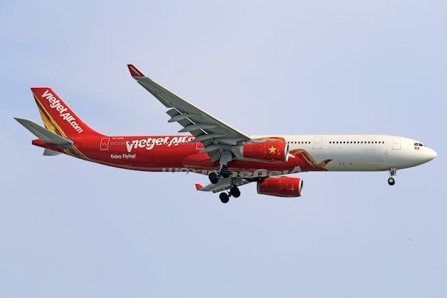 a red and white airplane flying in the sky