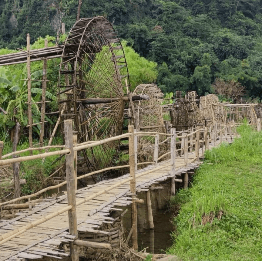 a wooden bridge with a water wheel